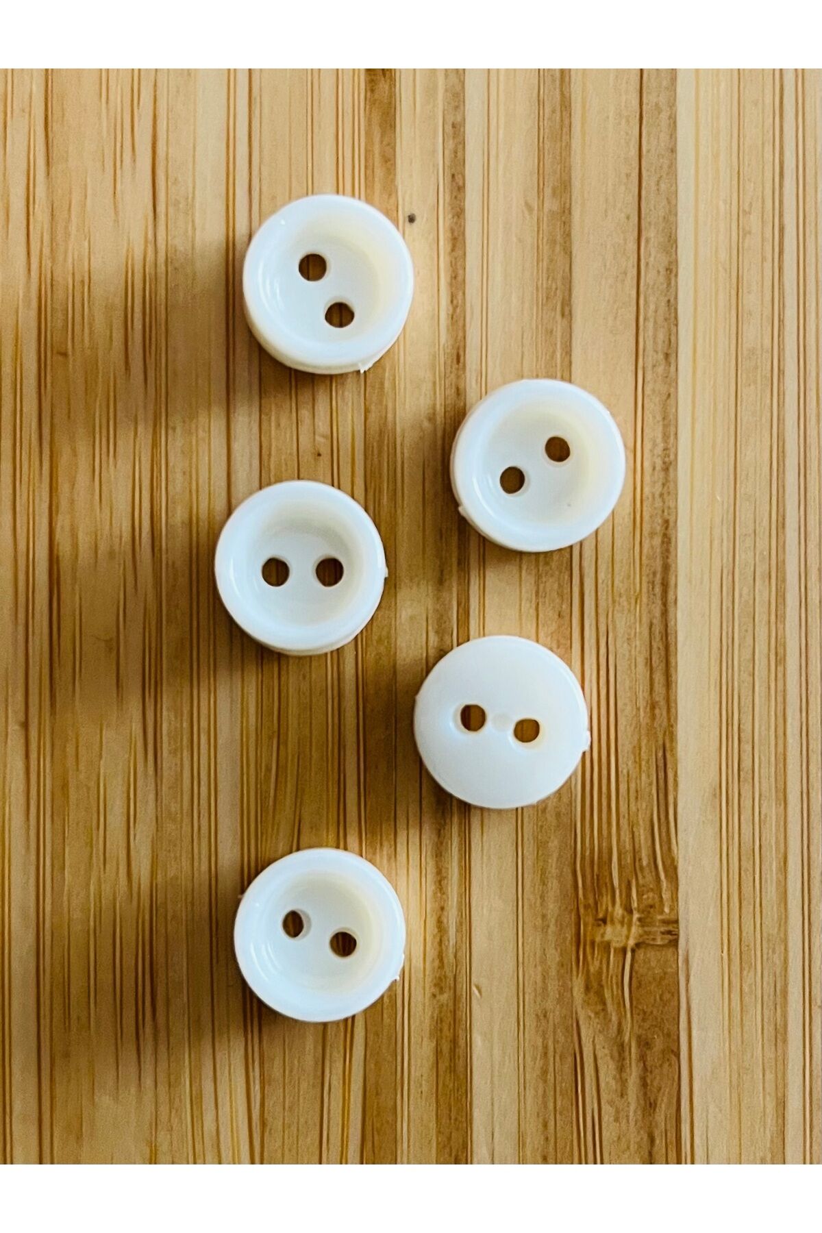 Üstten dikmeli krem bebe düğmesi. 5x11mm .Çanak.