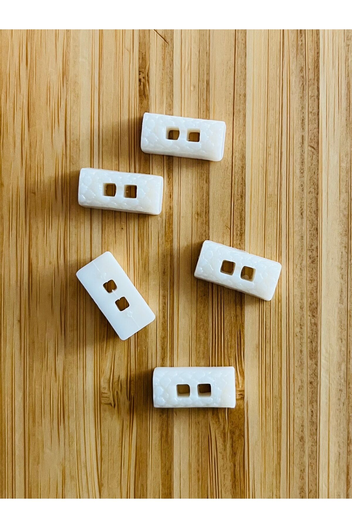 Üstten dikmeli krem bebe düğmesi. 8x16mm. Yarım Çoban Düğme Şekilli.