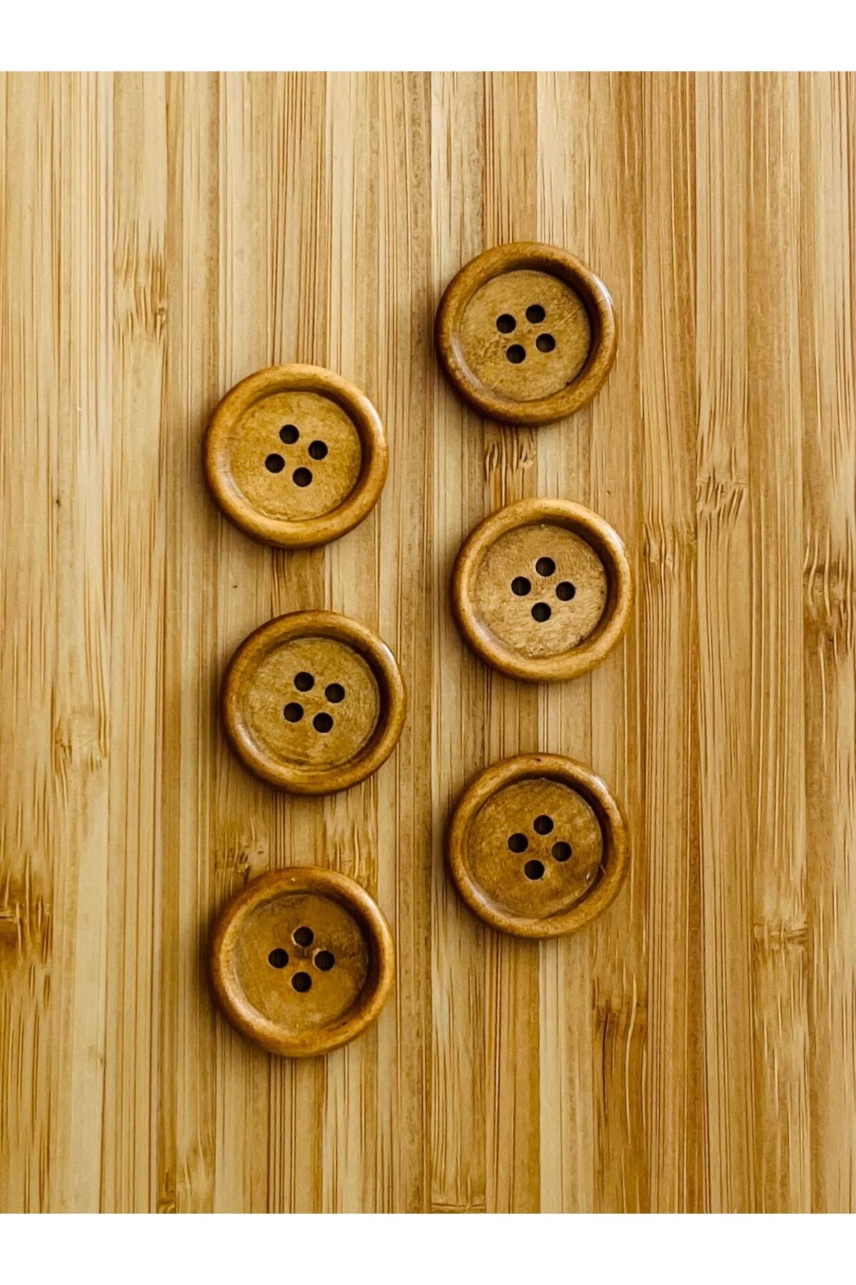 Ahşap düğme, natürel renk ve vernik kaplama. Yelek, pantolon, ferace, bluz vb. 25mm. 6 adet.